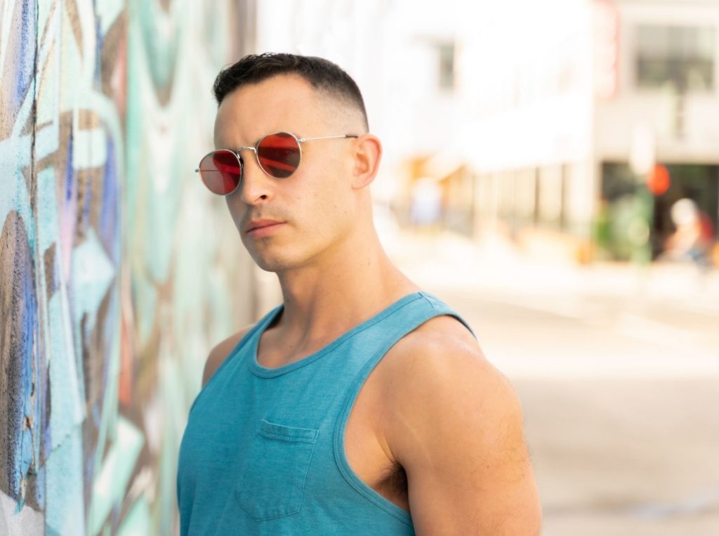 Male model posing for North Park photoshoot in tank top and glasses.